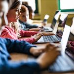 crianças em sala de aula estudando sob orientação de uma educação midiatica